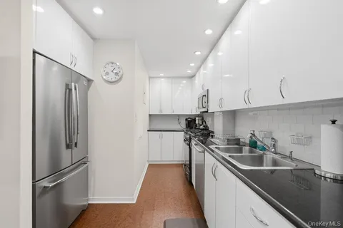 a kitchen with a sink a refrigerator and cabinets