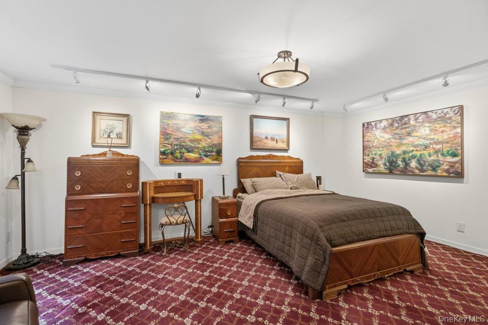 30 Stoner Avenue, Unit 1S Great Neck, NY 11021 - Photo 19 of 29 a bedroom with a bed and dresser with mirror