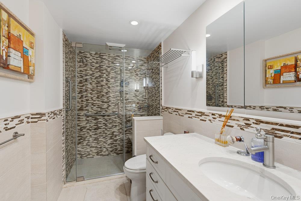 30 Stoner Avenue, Unit 1S Great Neck, NY 11021 - Photo 22 of 29 a bathroom with a sink toilet and shower