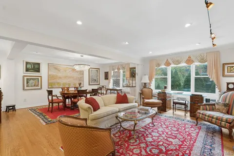 a living room with fireplace furniture and a large window