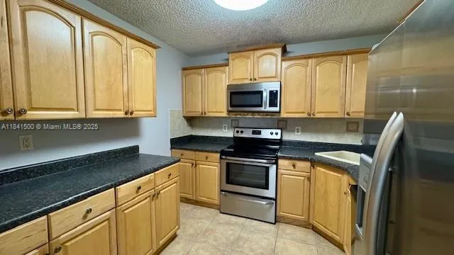 a kitchen with granite countertop a stove top oven microwave and cabinets