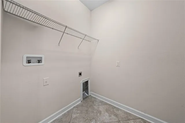 an empty room with chandelier fan and windows