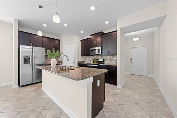 a large kitchen with granite countertop a stove sink and cabinets