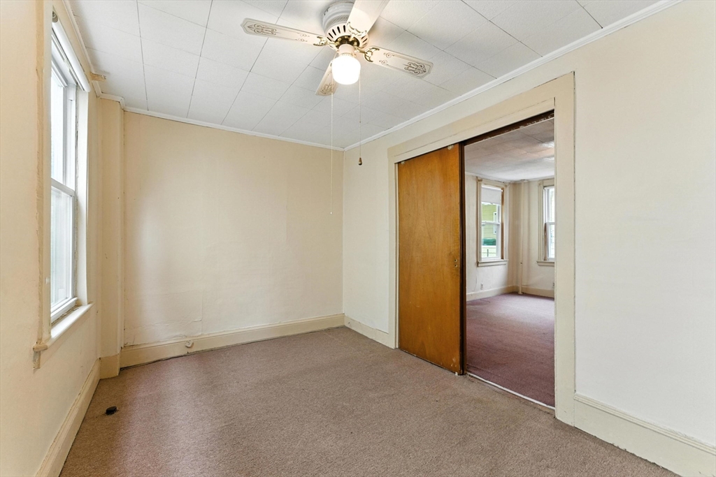 112 Grape Street Chicopee, MA 01013 - Photo 11 of 42 an empty room and chandelier fan windows