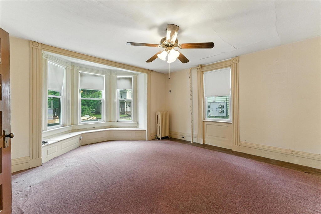 112 Grape Street Chicopee, MA 01013 - Photo 3 of 42 an empty room with windows and fan