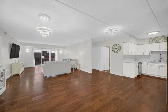 a view of empty room with wooden floor and fireplace