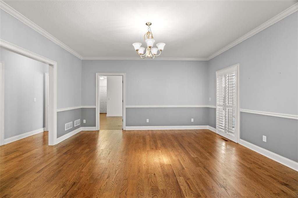 2058 Sewanee Court Villa Rica, GA 30180 - Photo 14 of 91 an empty room with wooden floor chandelier and windows