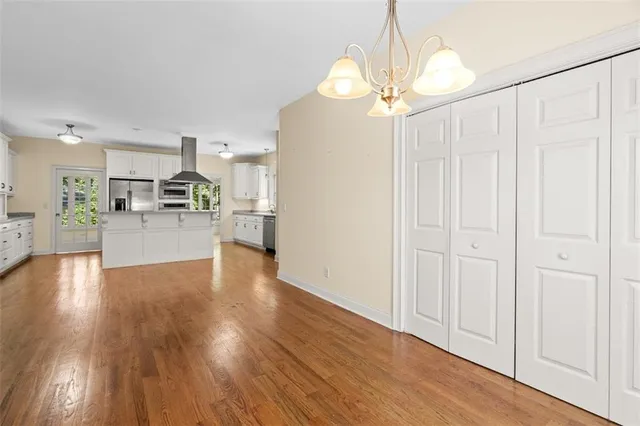 a view of an empty room with window and wooden floor