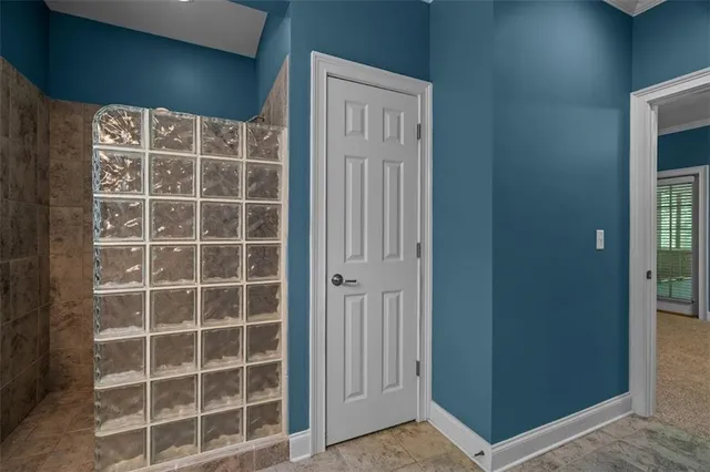 a view of a room with a bed and wooden floor