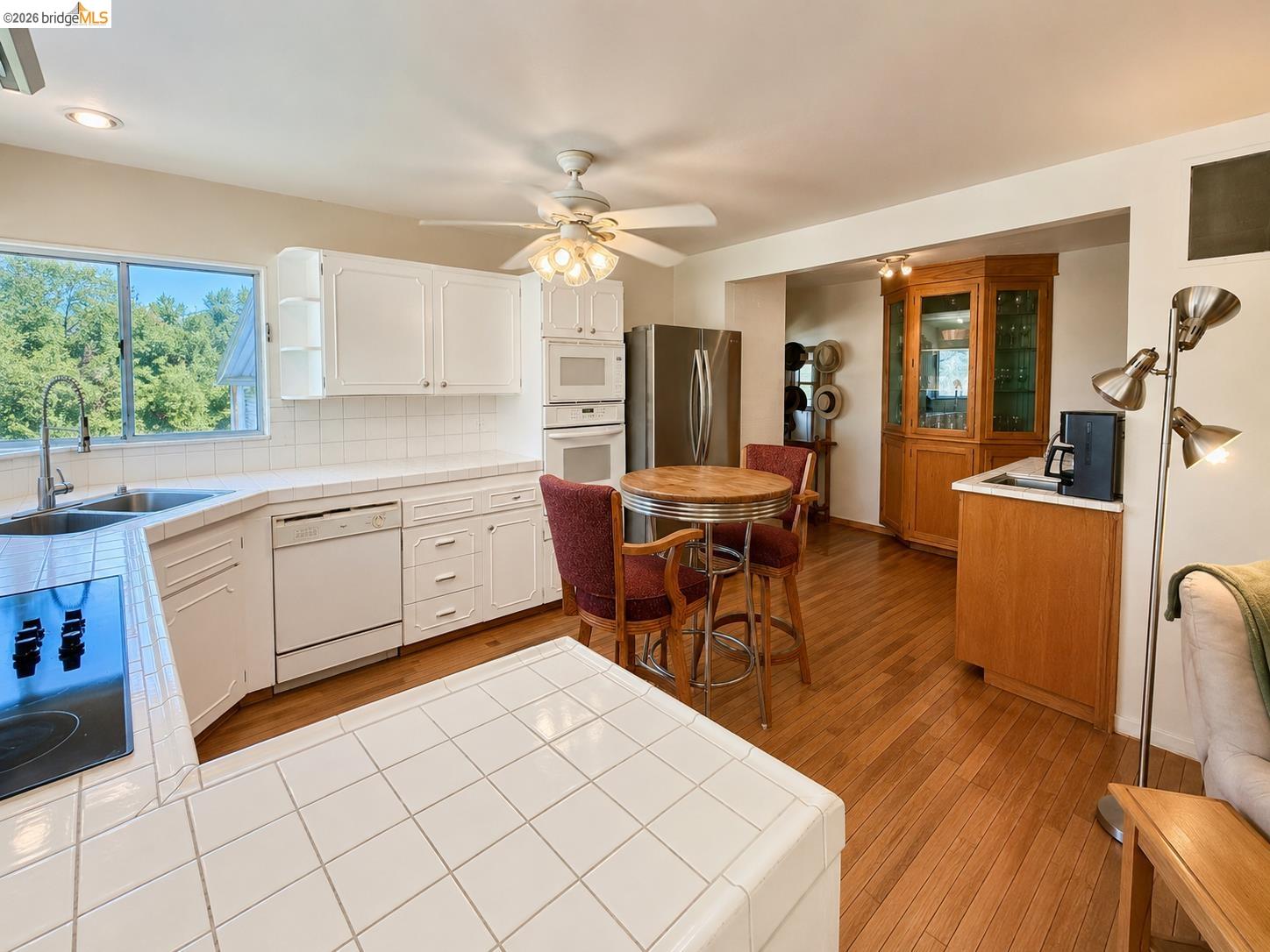 18195 Wards Ferry Road Sonora, CA 95370 - Photo 18 of 67 Kitchen featuring white cabinetry, tile countertops, and wood-finish flooring
