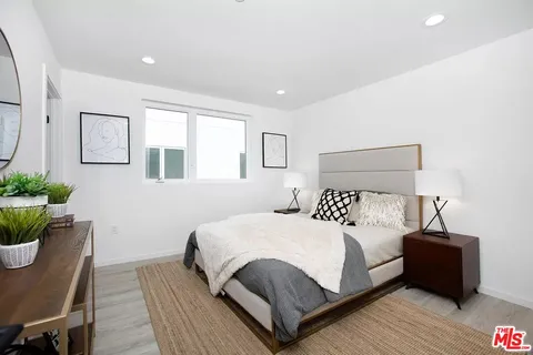 a bedroom with a bed and a potted plant