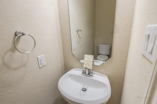 a bathroom with a sink a toilet and mirror