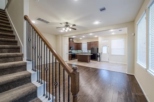 a view of a hallway with wooden floor and staircase