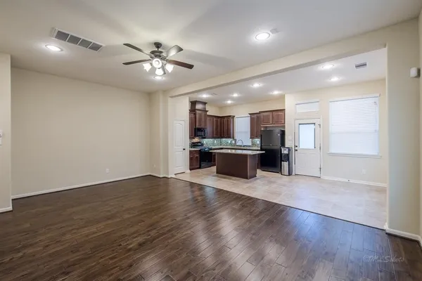 an open kitchen with a refrigerator and a microwave