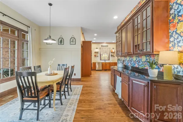 a dining room with stainless steel appliances granite countertop a table chairs and a refrigerator