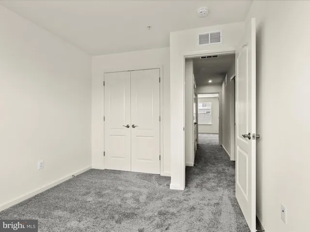 an empty room with a bench and a hallway