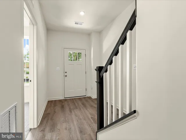 a view of a hallway with wooden floor and entryway