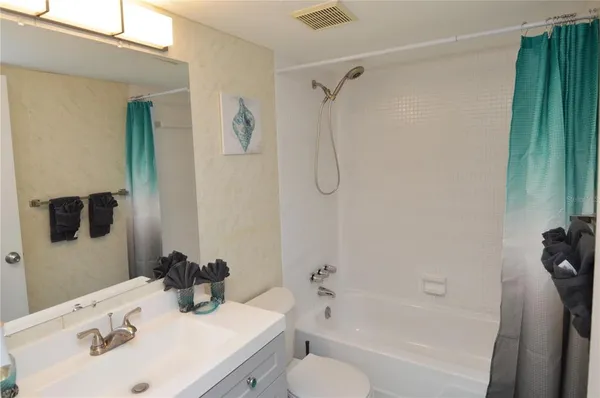 a front view of a building with garden and trees