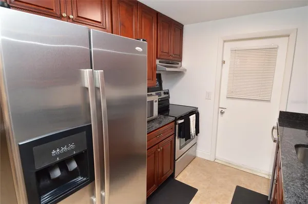 a kitchen with stainless steel appliances granite countertop a refrigerator and a stove top oven