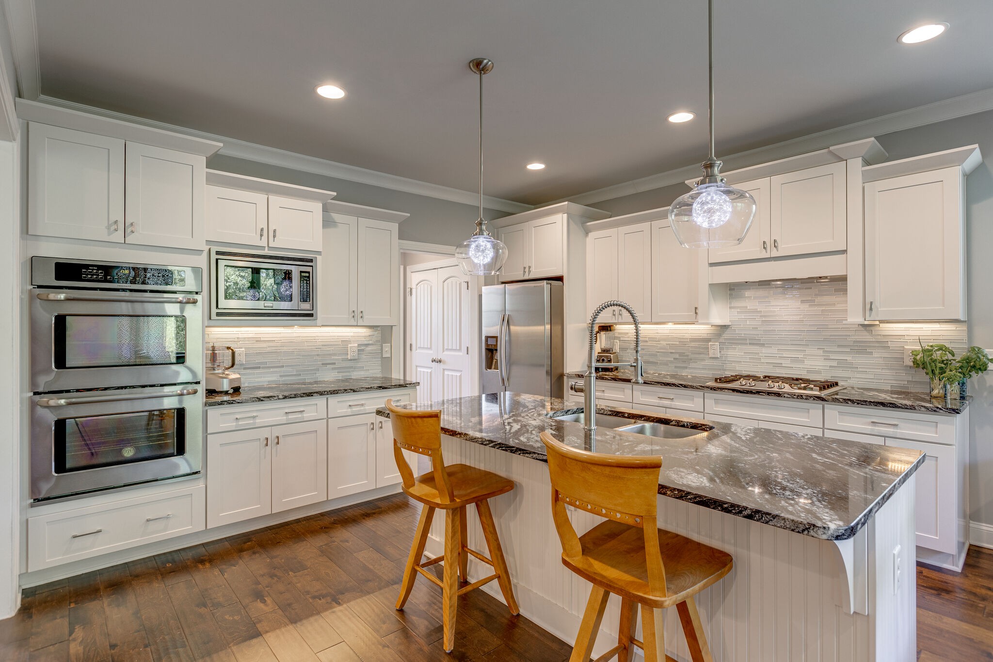 a kitchen with granite countertop kitchen island white cabinets and stainless steel appliances