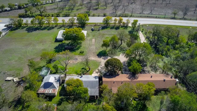 an aerial view of a house with a yard and lake view