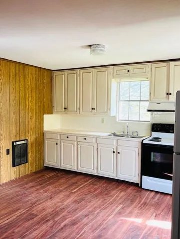 a view of a kitchen with wooden floor and electronic appliances