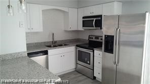 357 US Highway 27 South Sebring, FL 33870 - Photo 3 of 10 a kitchen with stainless steel appliances granite countertop a stove a microwave and a refrigerator