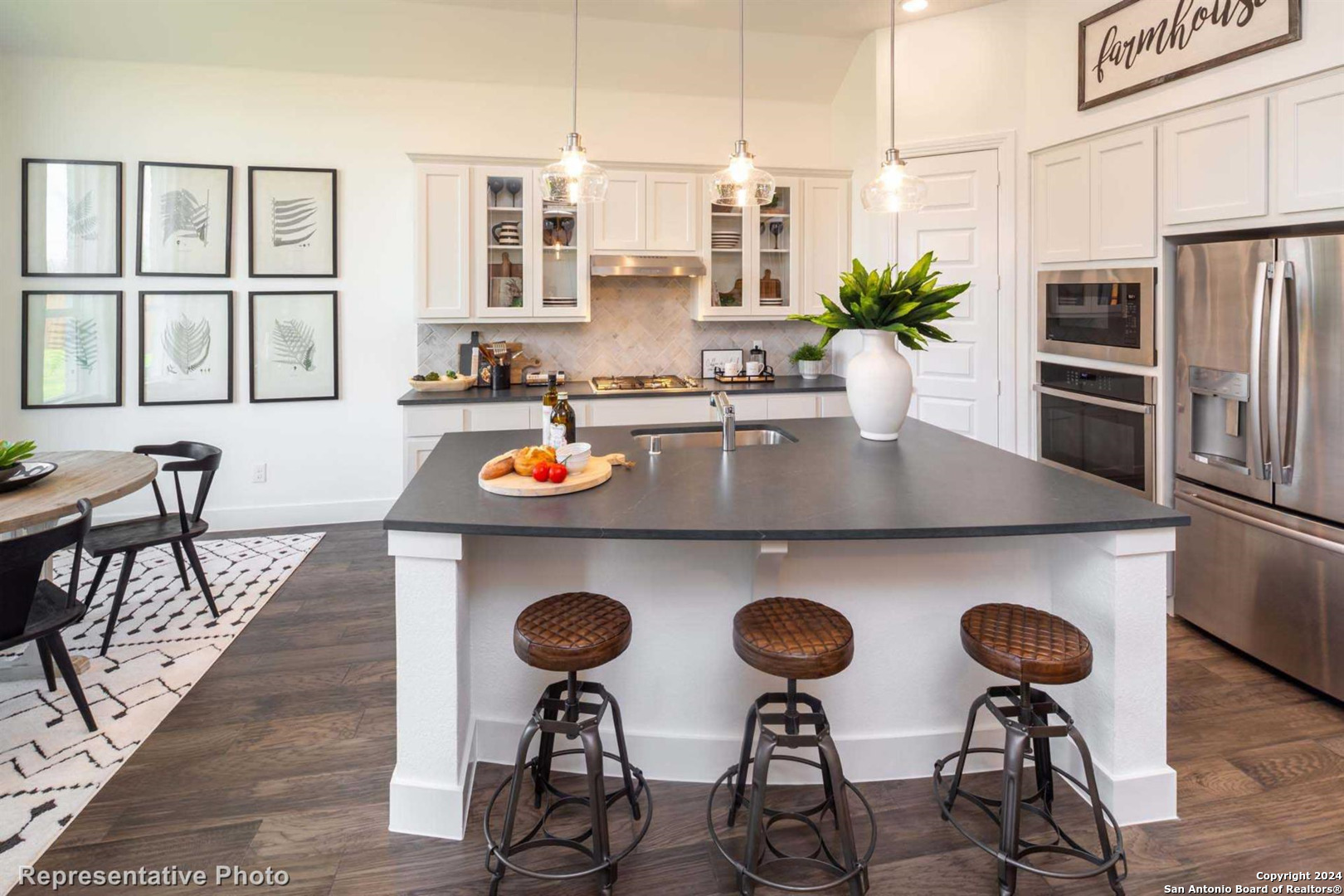 a kitchen with stainless steel appliances granite countertop a dining table chairs stove and sink