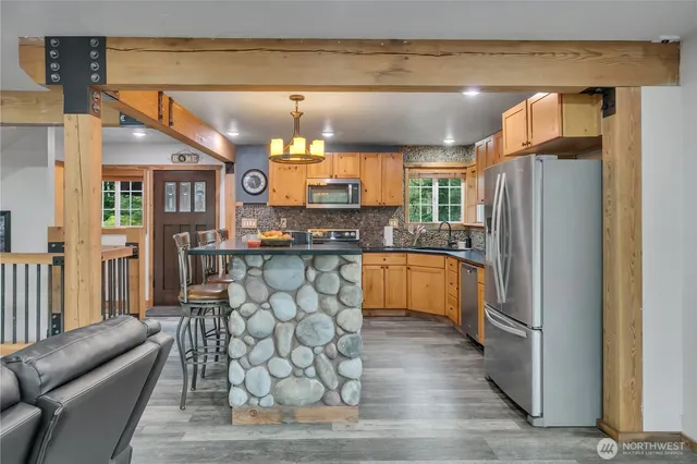 a kitchen with granite countertop a refrigerator a stove a dining table and chairs