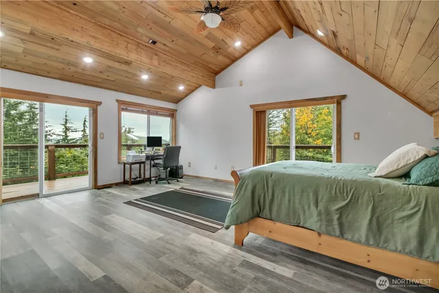 a bed sitting in a spacious bedroom next to a window