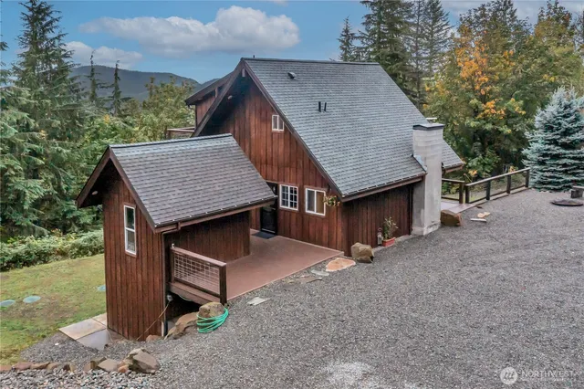 a view of a house with a yard and large tree