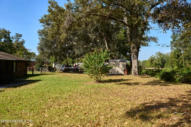 a view of a house with backyard and a tree
