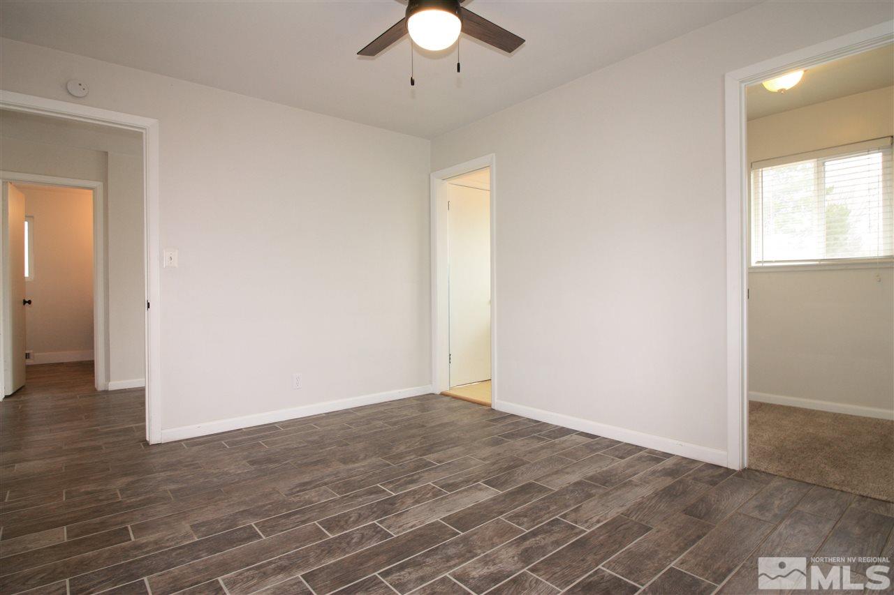 1280 Tacoma Way Reno, NV 89509 - Photo 15 of 36 an empty room with wooden floor chandelier fan and windows