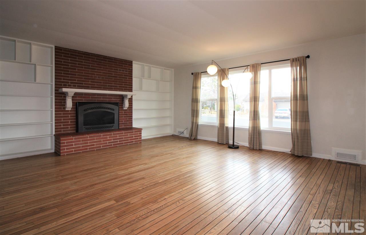 1280 Tacoma Way Reno, NV 89509 - Photo 4 of 36 an empty room with wooden floor fireplace and windows