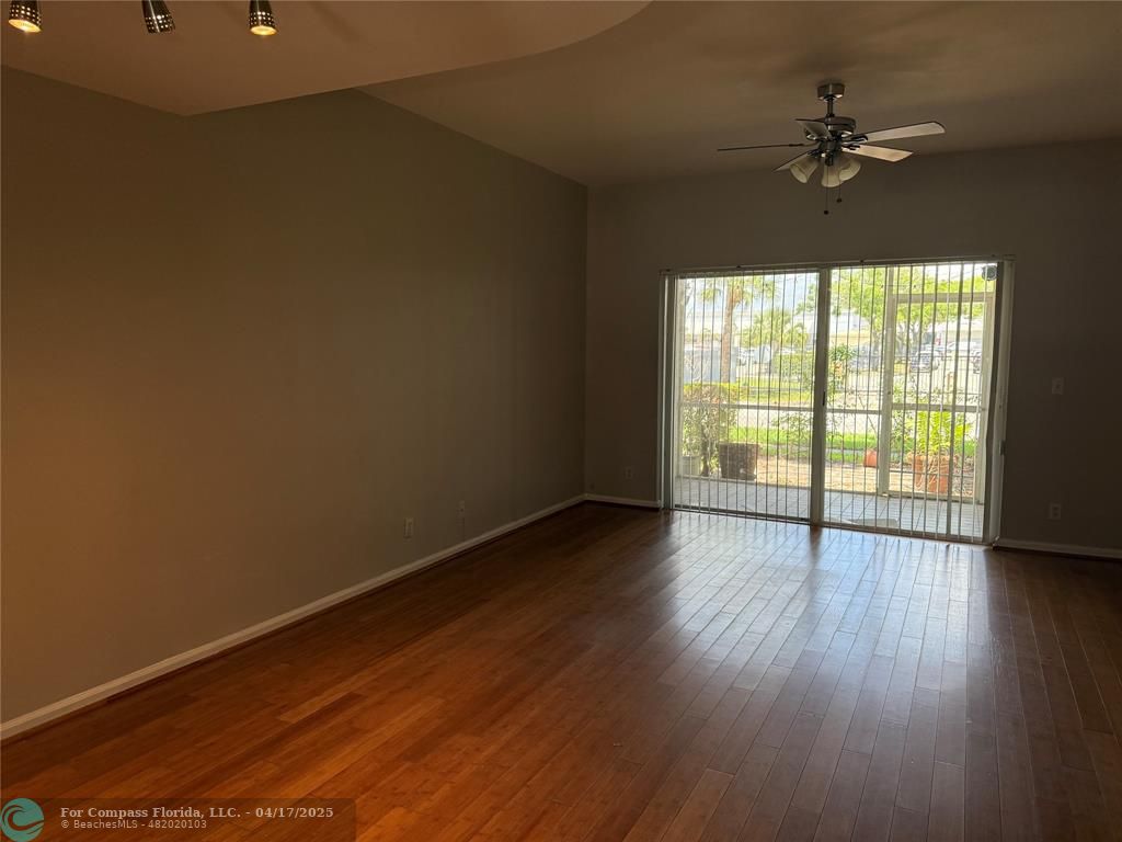 5295 Jamboree Place Margate, FL 33063 - Photo 12 of 35 a view of an empty room with wooden floor and a window