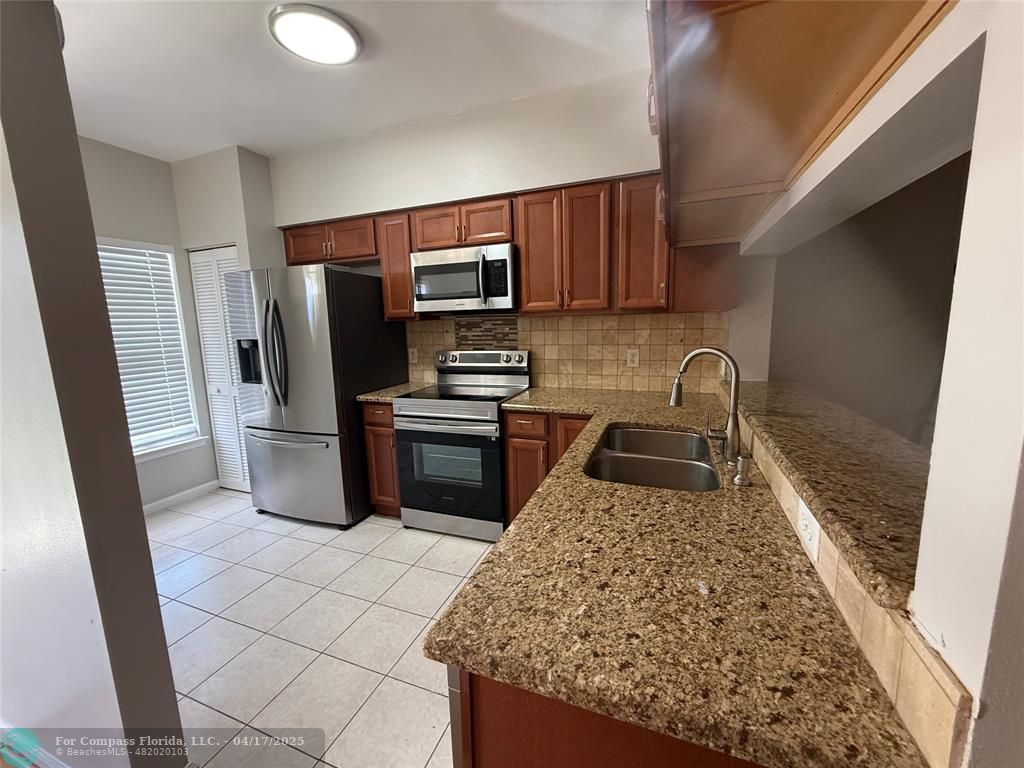 5295 Jamboree Place Margate, FL 33063 - Photo 5 of 35 a kitchen with stainless steel appliances granite countertop a sink stove and refrigerator