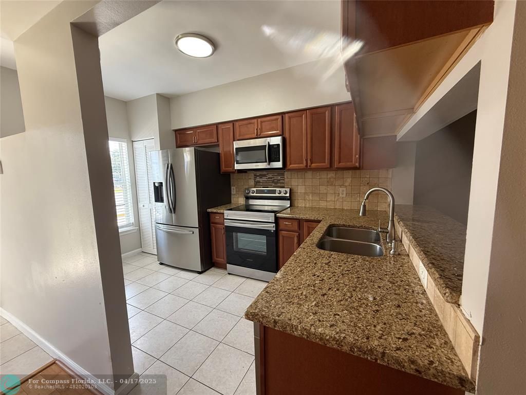5295 Jamboree Place Margate, FL 33063 - Photo 7 of 35 a kitchen with granite countertop a refrigerator and a stove top oven