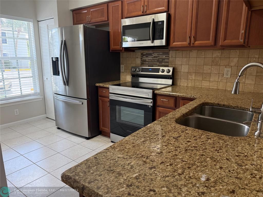 5295 Jamboree Place Margate, FL 33063 - Photo 8 of 35 a kitchen with stainless steel appliances granite countertop a refrigerator sink and microwave
