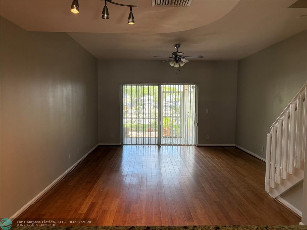 5295 Jamboree Place Margate, FL 33063 - Photo 9 of 35 an empty room with wooden floor chandelier and windows