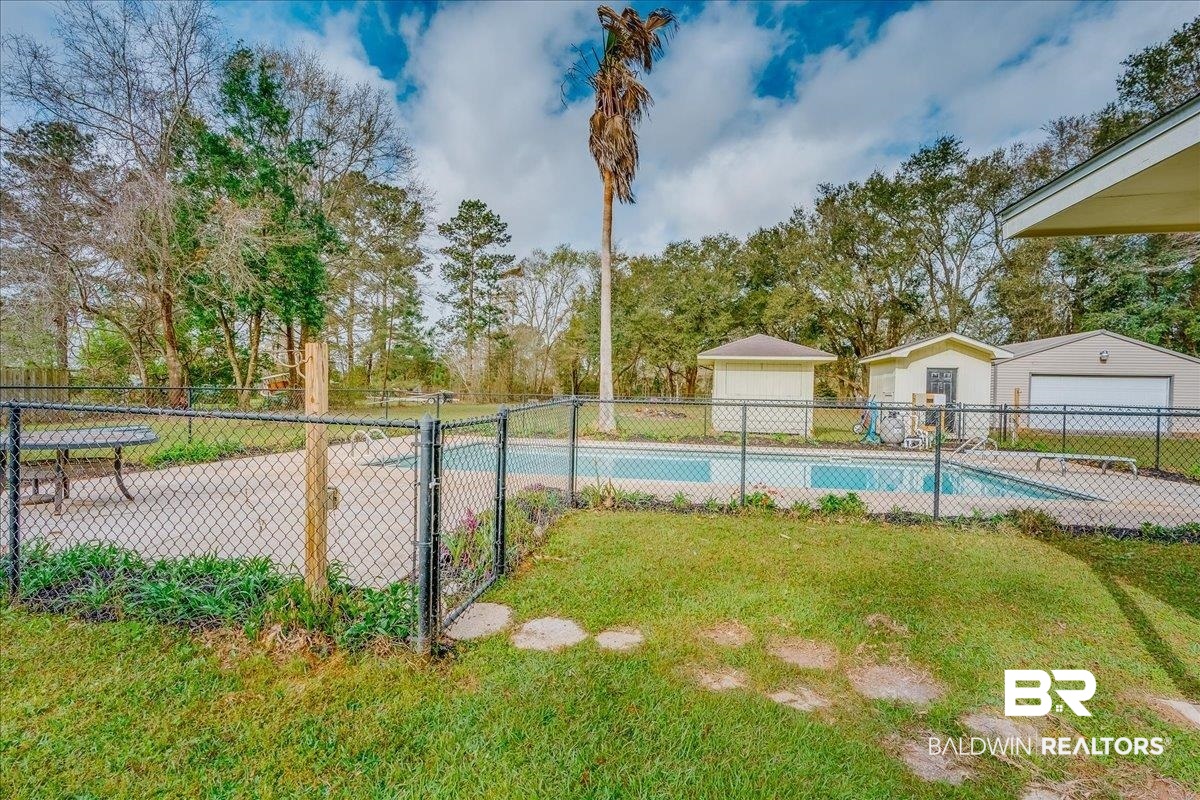 440 Dykes Road Mobile, AL 36608 - Photo 32 of 49 View of swimming pool featuring an outdoor structure, a yard, fence, and a fenced in pool