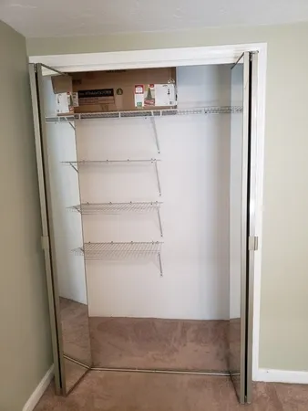 a view of walk in closet with empty racks