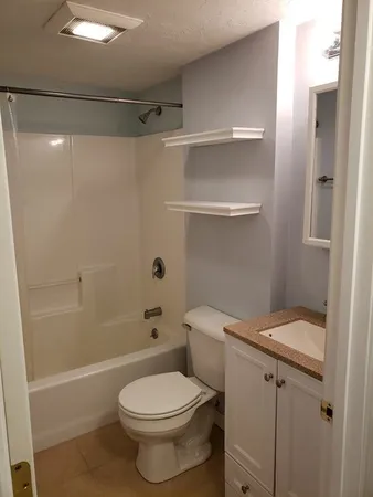 a white toilet sitting next to a bath tub
