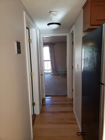 a view of a hallway with wooden floor and staircase