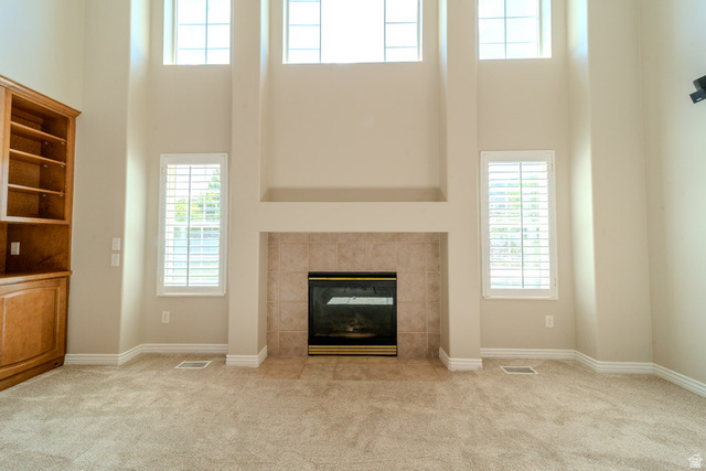598 Hollow Creek Road Draper, UT 84020 - Photo 27 of 110 Soaring two-story ceilings frame a central fireplace with a tile surround and hearth
