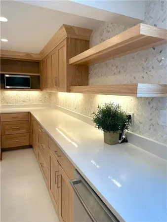 a view of a kitchen with stainless steel appliances a sink and a refrigerator