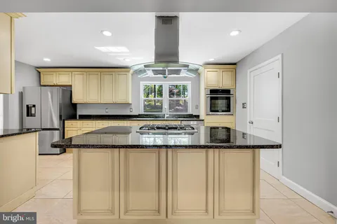 a view of a kitchen with stainless steel appliances granite countertop a stove and a refrigerator