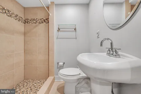 a bathroom with a sink a toilet and shower