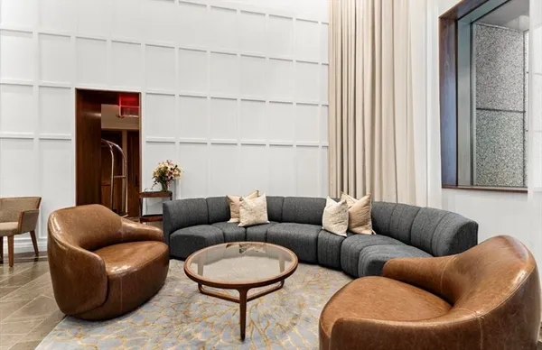 a living room with furniture a rug and a window