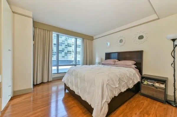 a bedroom with a bed and a large window