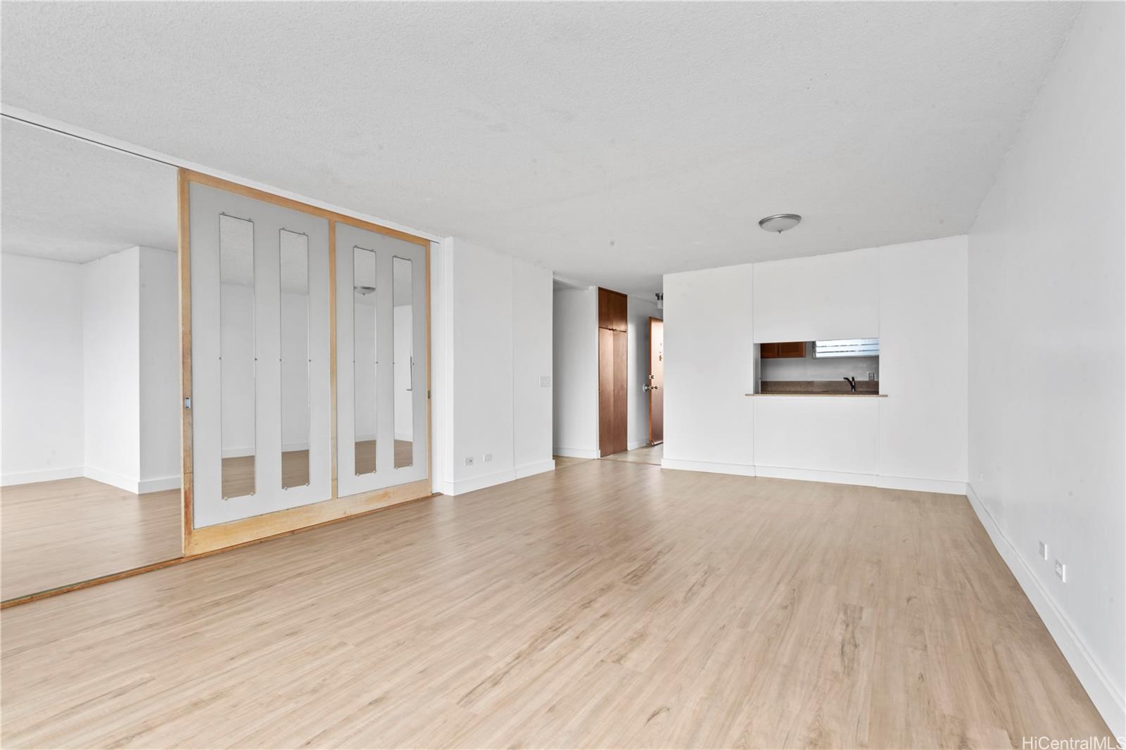 1018 Lunalilo Street, Unit 603 Honolulu, HI 96822 - Photo 2 of 12 an empty room with wooden floor and windows